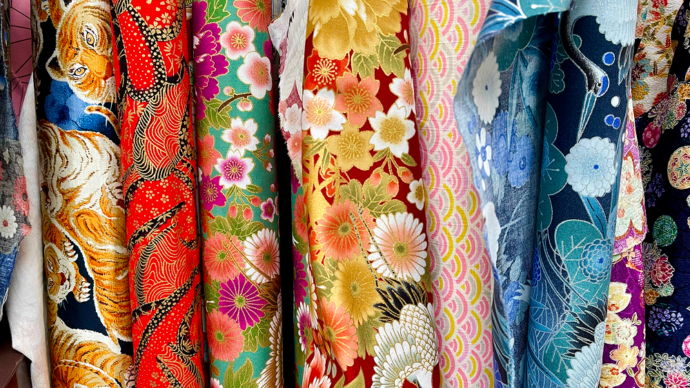 Colorful patterned fabric rolls in close-up.