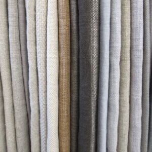 A selection of neutral-colored fabric rolls arranged vertically.