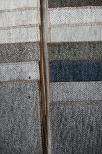 Samples of fabric swatches in neutral and blue tones arranged in rows.