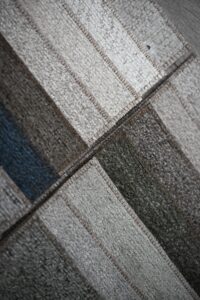 Close-up of textured fabric with intersecting lines in neutral tones.