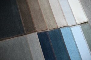 Various fabric swatches in neutral and blue tones arranged in rows.