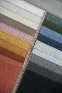 Stacked fabric swatches in various colors arranged neatly.