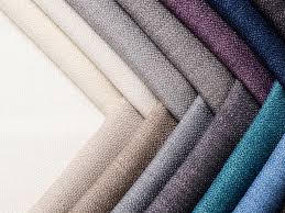 Close-up of folded textured fabrics in various shades.